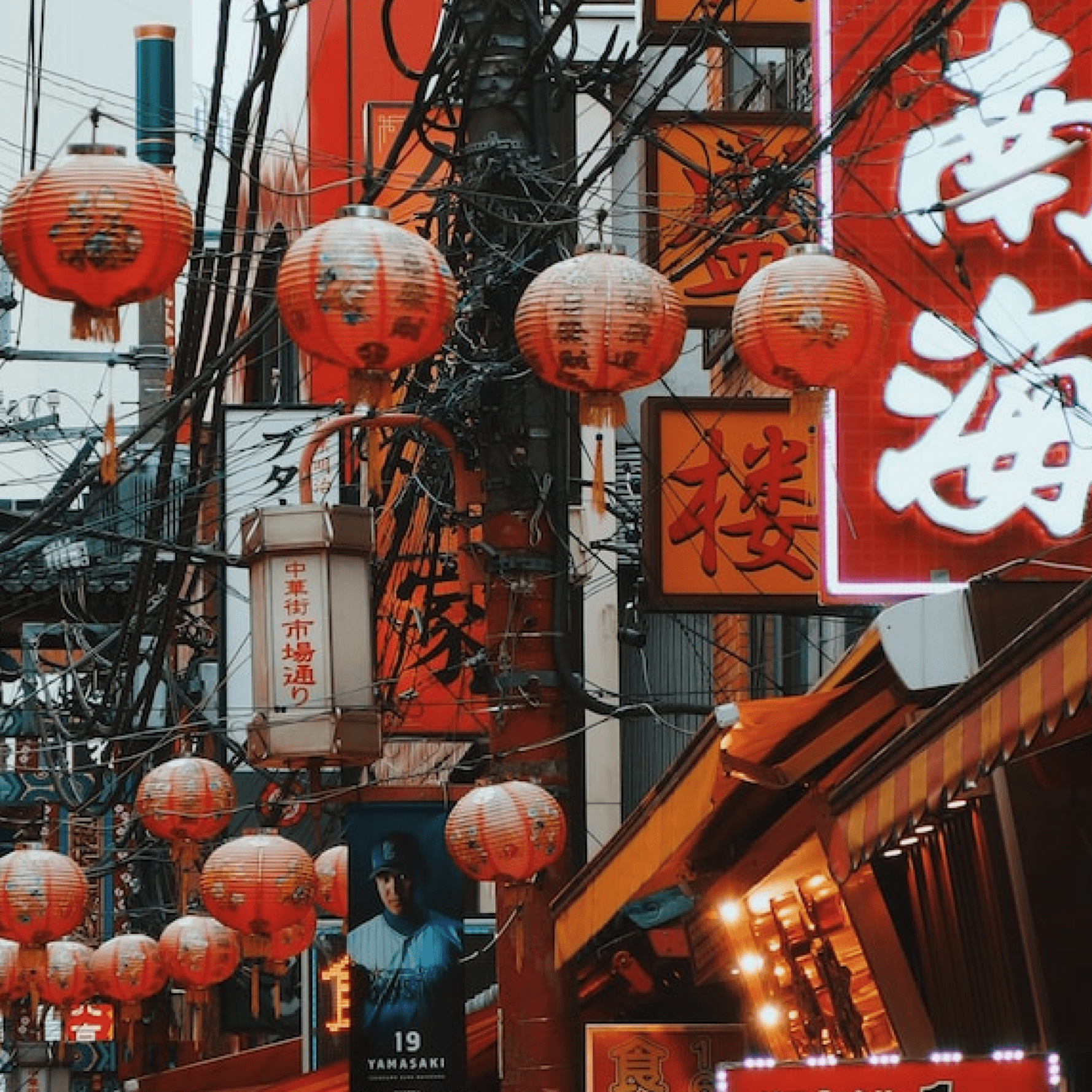 Paper lanterns hanging among street signs in Chinese